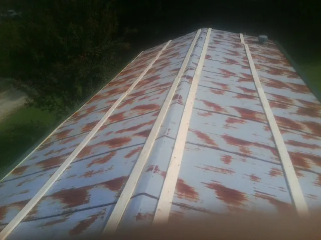 Rusted metal roof panels with new wood purlins before replacement — Storm Damage Roof Repair in Weslaco by Roofing Brothers