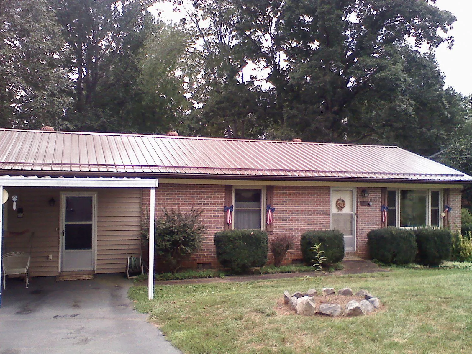 Bronze metal roof and carport on a brick ranch home — Roof Repair work by our crew in Weslaco