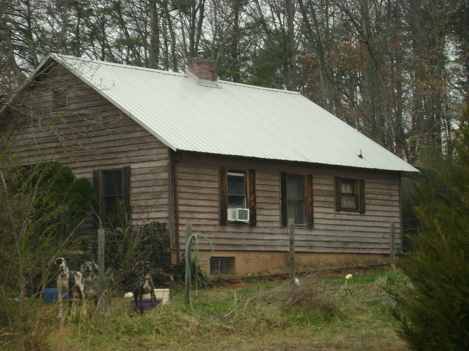 White metal roof on an old wood sided farmhouse, from a Metal Roof Installation job in Weslaco